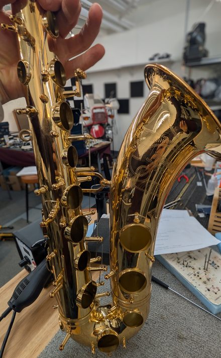 Saxophone body and bell being inspected during a repair